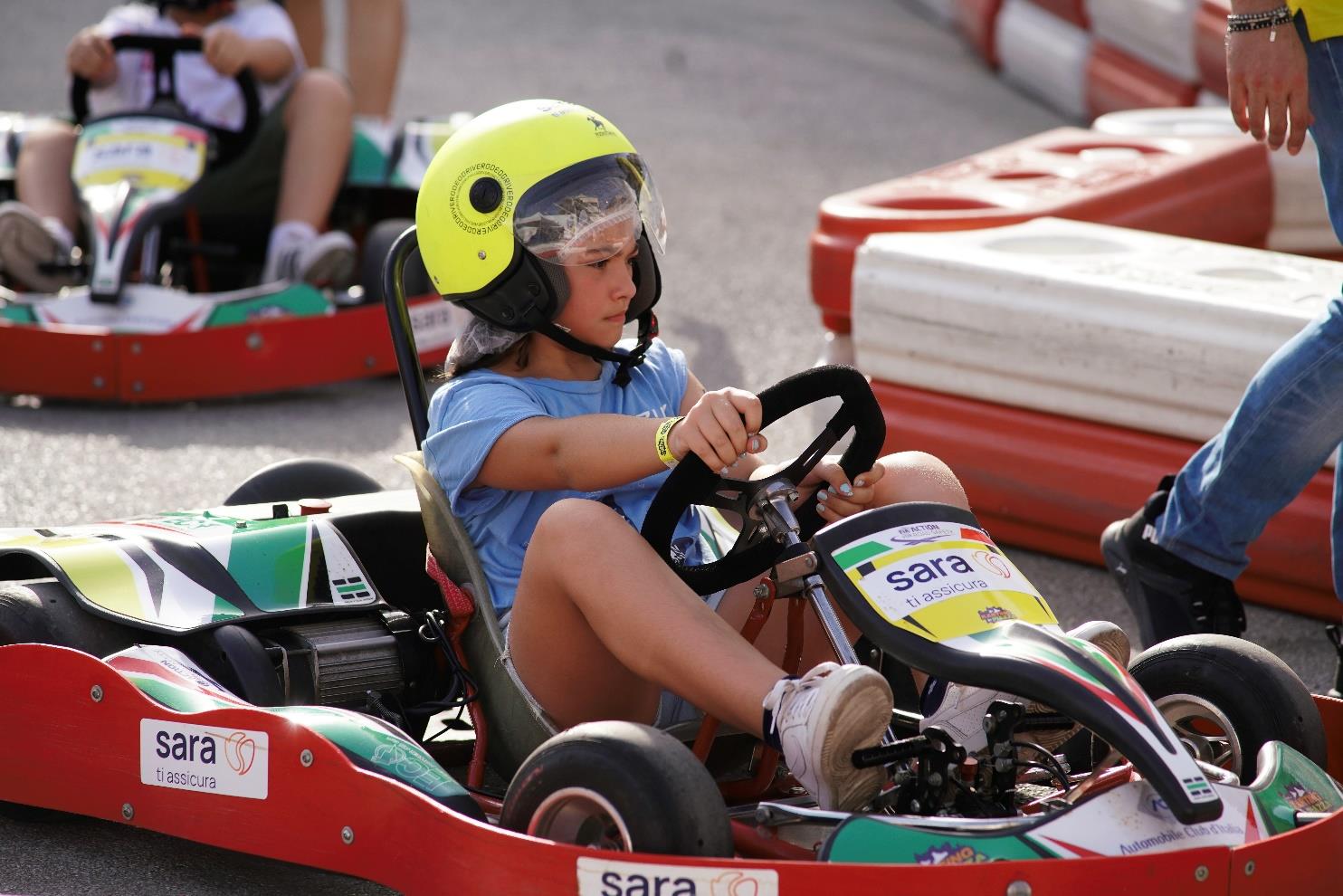 Una bambina alla guida di un kart elettrico durante Karting in Piazza
