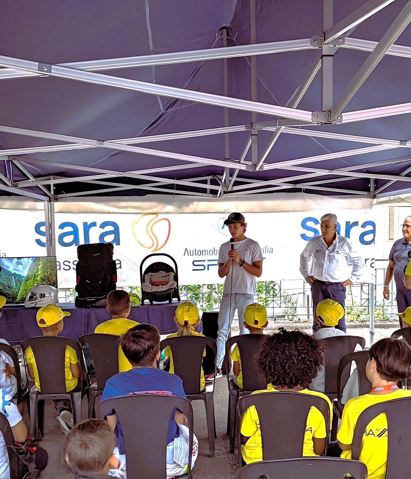 Incontro tra i bambini e un testimonial del motorsport